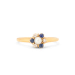Gold ring with a central pearl and sapphires on a white background